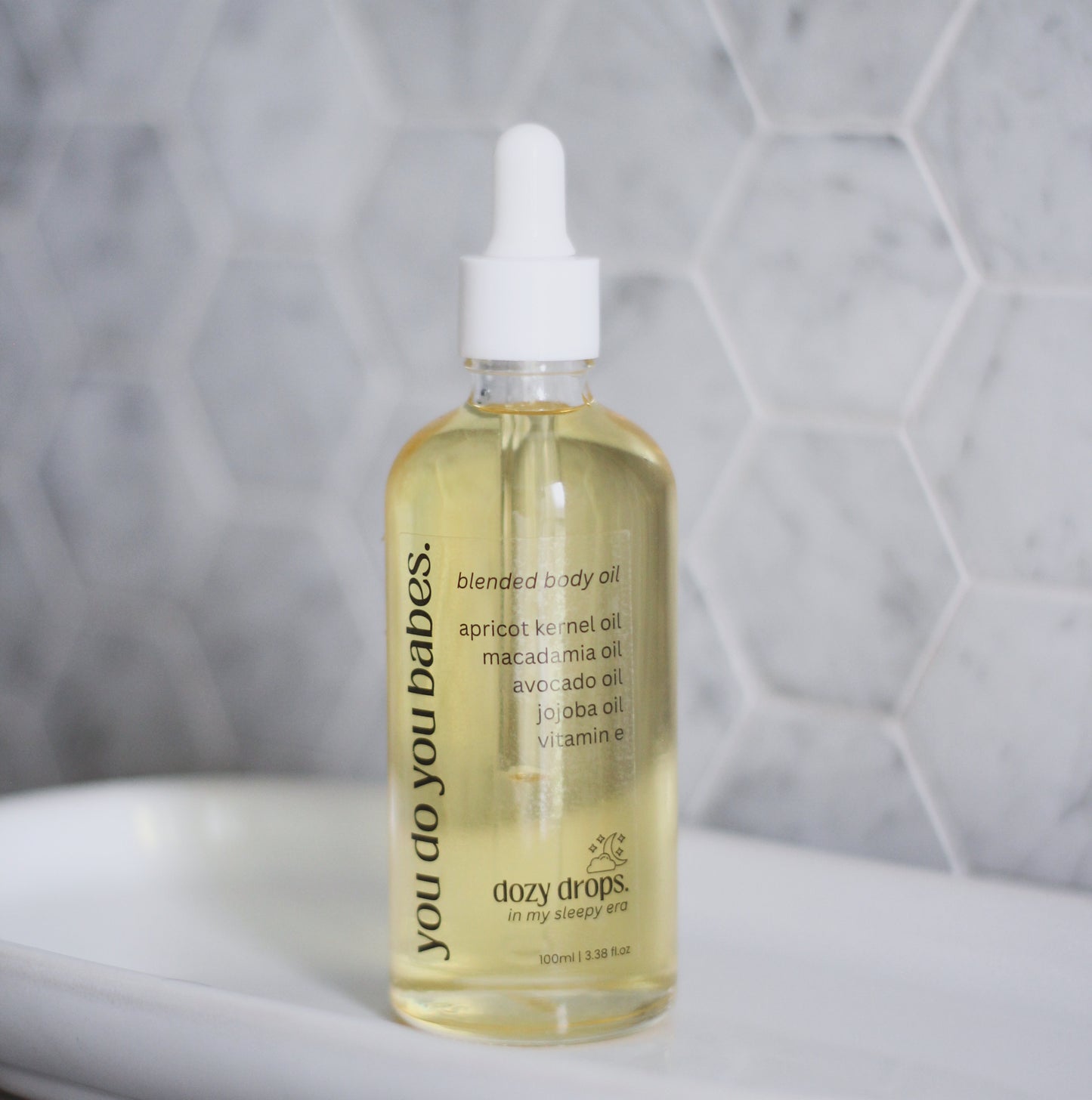 Bottle of dozy drops blended body oil with a dropper in a bathroom