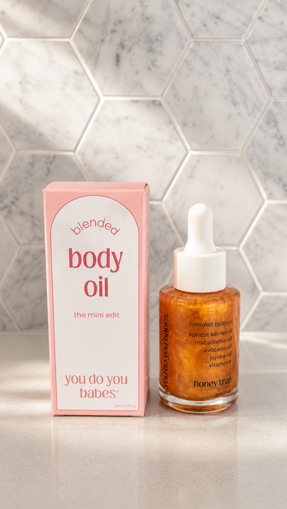 Bottle of body oil and its packaging on a tiled surface