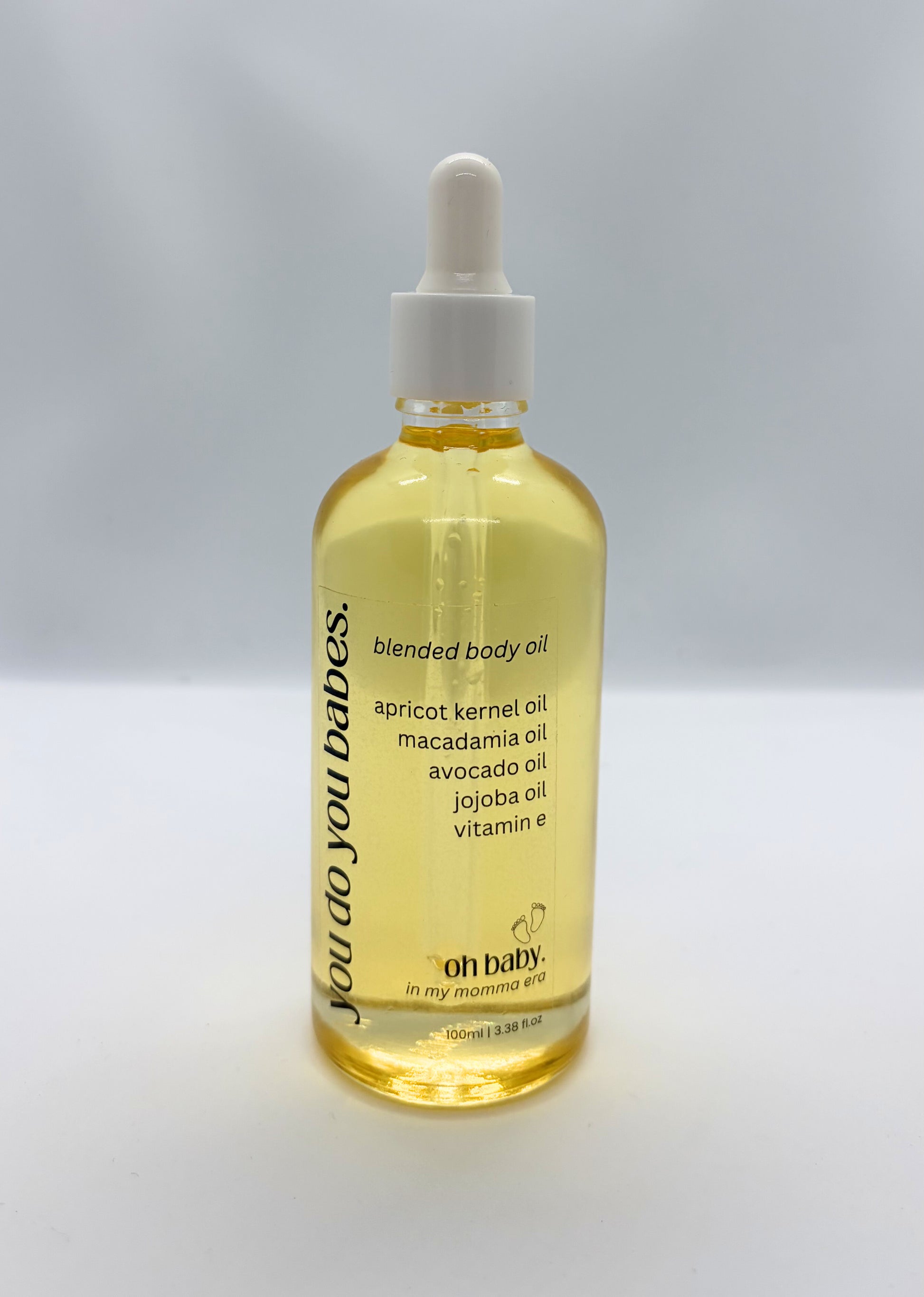 Bottle of blended oh baby body oil with a dropper on a white background