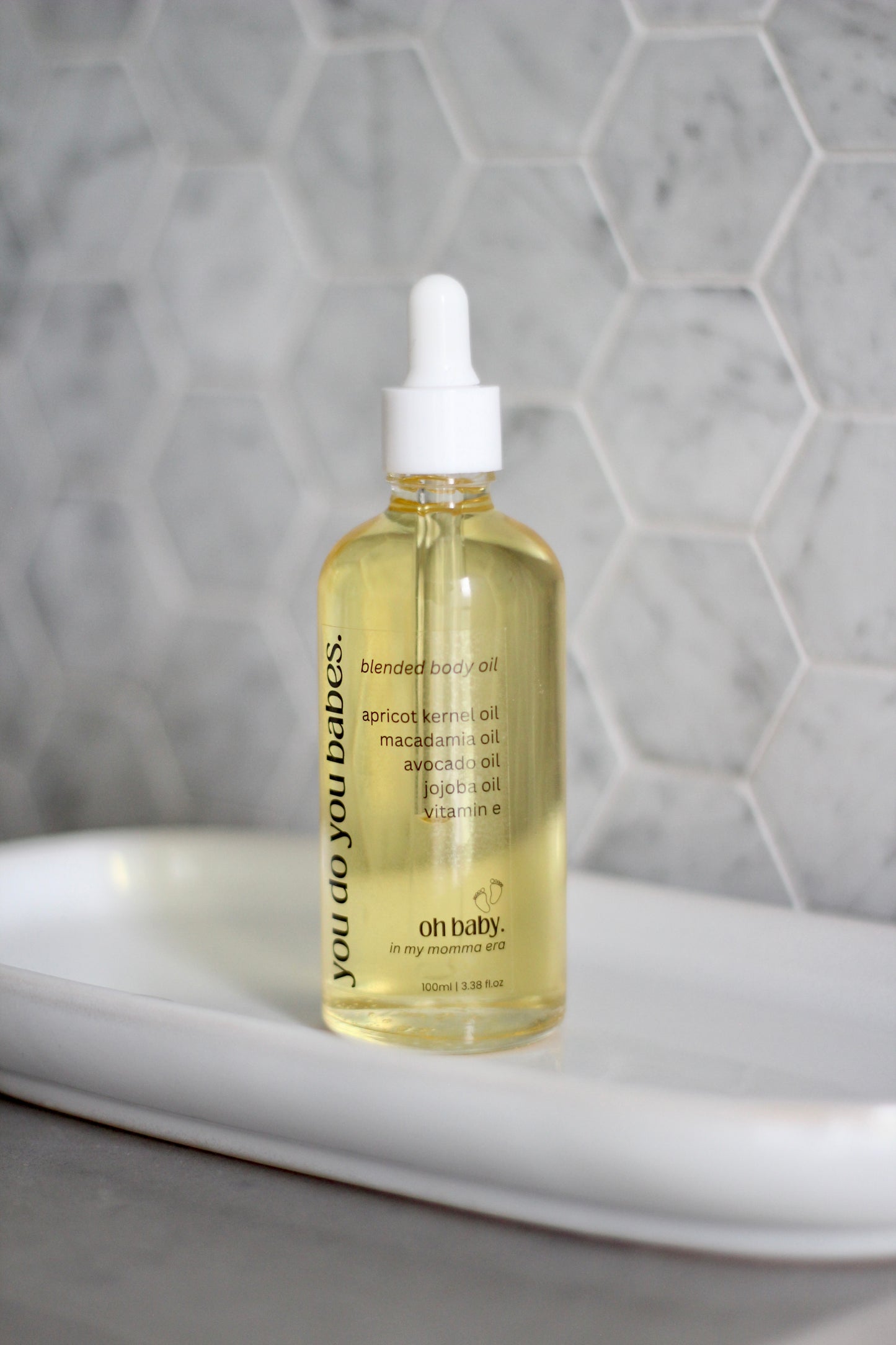 Bottle of 'oh baby!' Body oil with a dropper in a bathroom