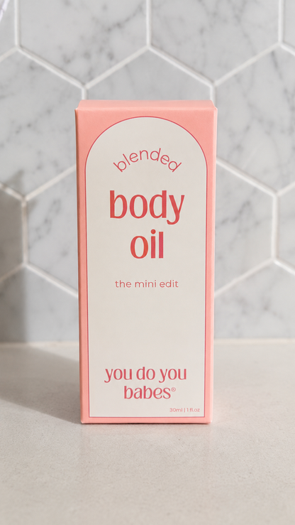 Box of 'blended body oil' with 'you do you babes' branding on a tiled wall background