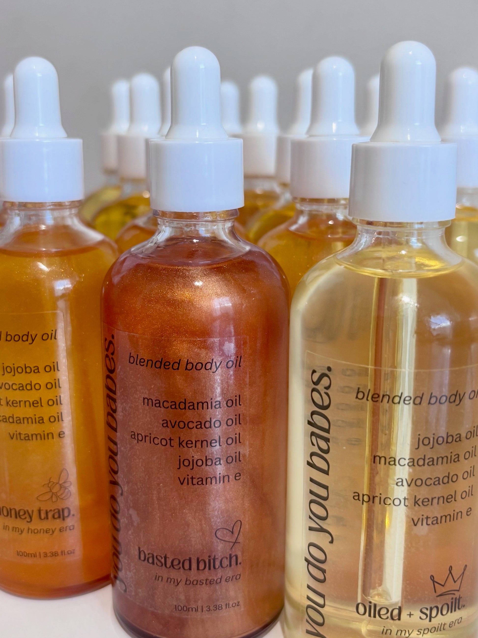 Bottles of blended body oil with dropper caps on a white background