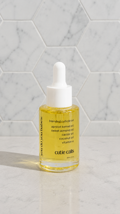Bottle of cutie calls cuticle oil on a marble surface from you do you babes 
