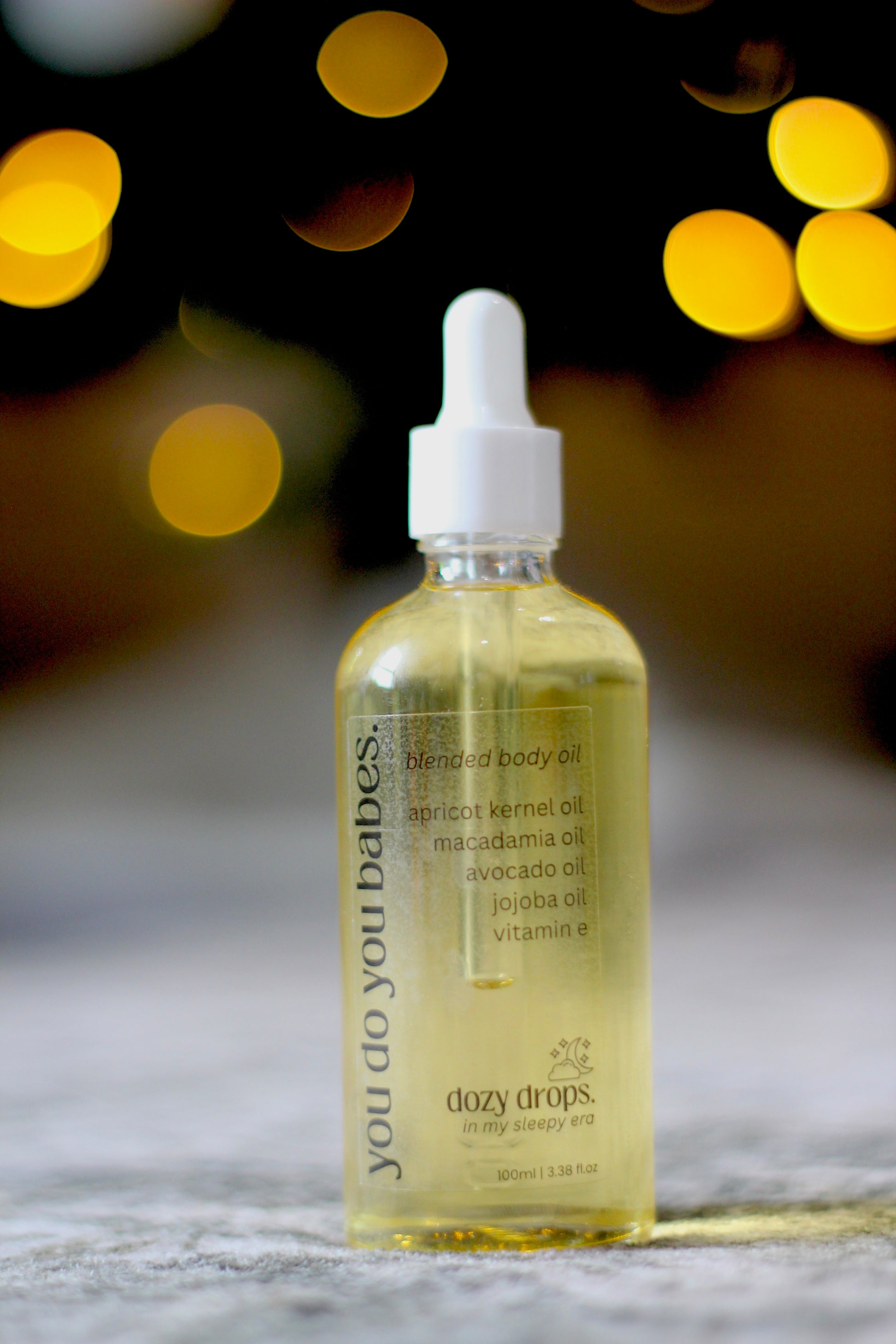 Bottle of 'dozy drops' body oil with a dropper on a blurred background
