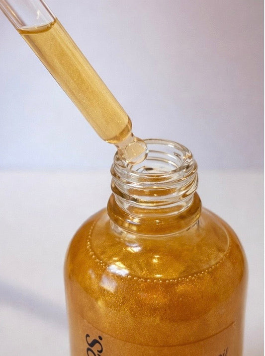 Bottle of blended body oil with a dropper on a white background