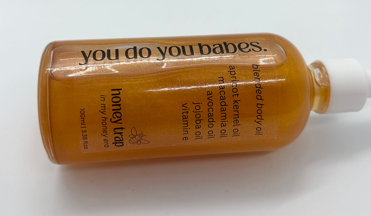 Honey trap body oil bottle with 'you do you babes' branding on a white background
