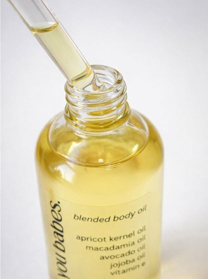 Bottle of oh baby blended body oil with a dropper on a light background