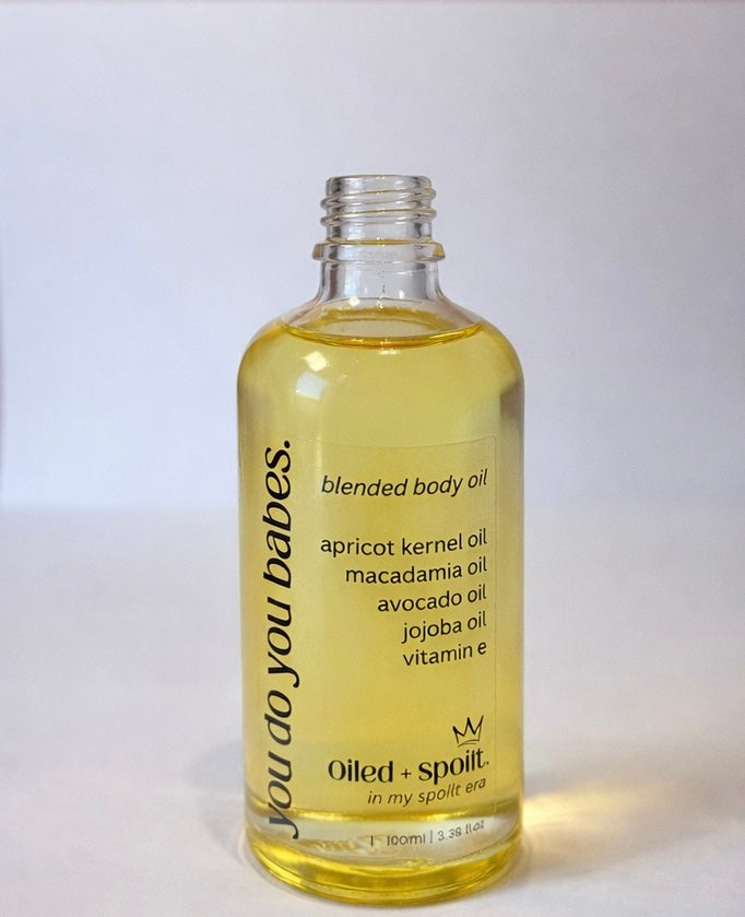 Bottle of blended body oil with a white background
