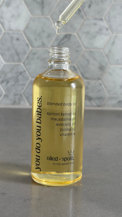 Bottle of blended body oil with dropper on a gray surface and marble background
