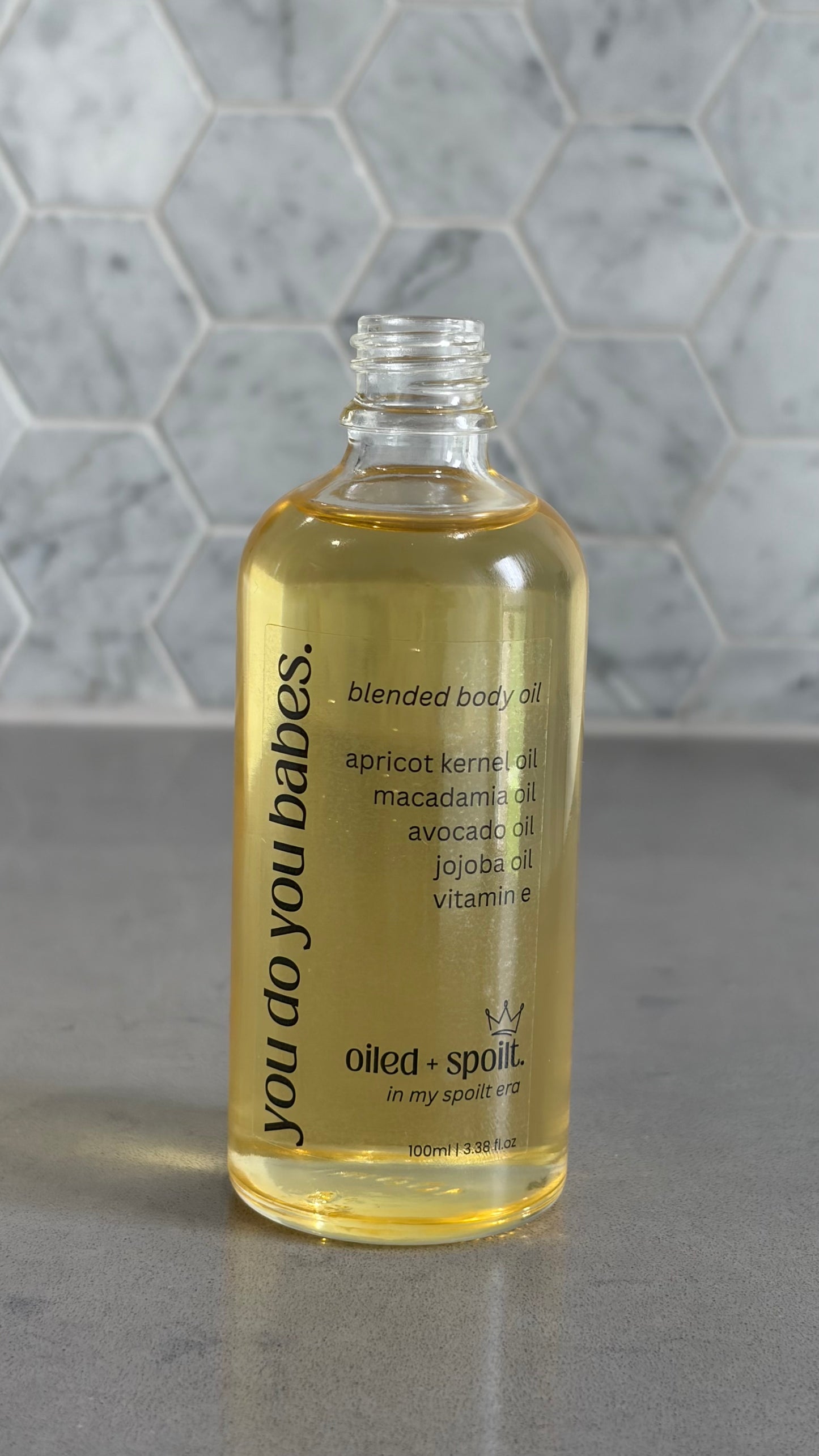 Bottle of blended body oil with a hexagonal tile background