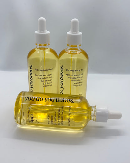 Three bottles of 'you do you babes' blended body oil on a light gray background