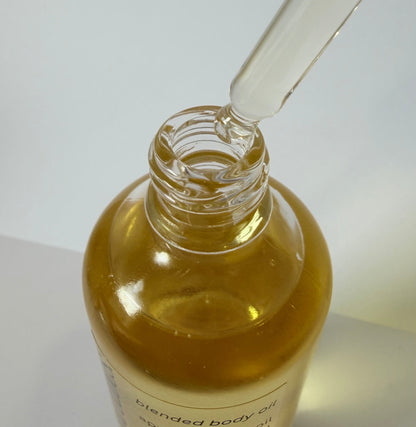Glass bottle with dropper containing oil on a white background